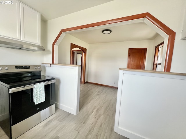 610 NE N St, Hermiston, OR 97838 - kitchen featuring electric stove, under cabinet range hood, light wood-style floors, white cabinetry, and arched walkways