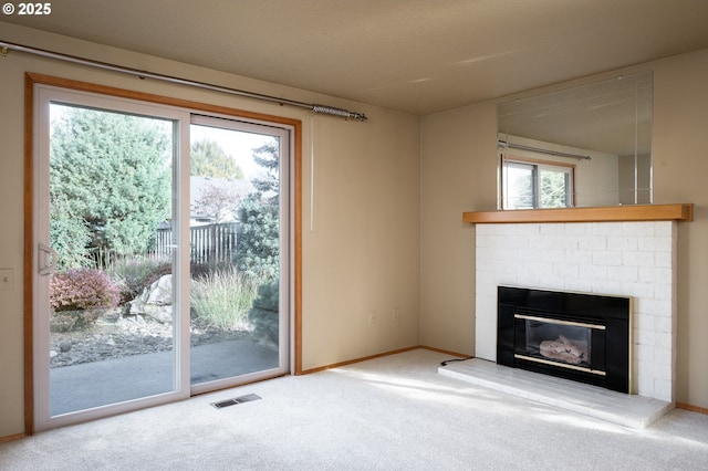 unfurnished living room with carpet, plenty of natural light, and a fireplace