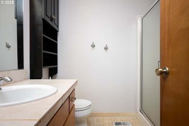 bathroom with a shower with door, tile patterned floors, toilet, and vanity