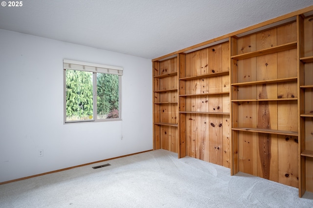 carpeted empty room featuring a textured ceiling