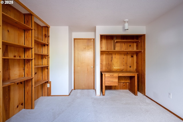 unfurnished bedroom with a textured ceiling and light colored carpet