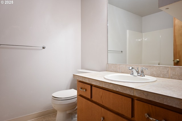 bathroom with toilet, vanity, tile patterned flooring, and a shower