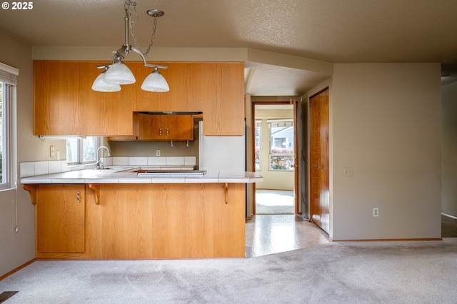 kitchen featuring a kitchen breakfast bar, a textured ceiling, and kitchen peninsula