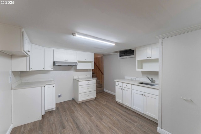 3826 SE 50th Ave, Portland, OR 97206 - kitchen featuring wood finished floors, white cabinets, under cabinet range hood, and light countertops