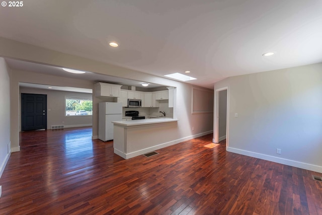 3826 SE 50th Ave, Portland, OR 97206 - kitchen featuring freestanding refrigerator, stainless steel microwave, open floor plan, white cabinetry, and dark wood-style floors