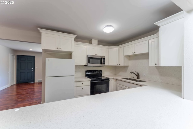 3826 SE 50th Ave, Portland, OR 97206 - kitchen featuring freestanding refrigerator, stainless steel microwave, black electric range oven, light countertops, and white cabinetry