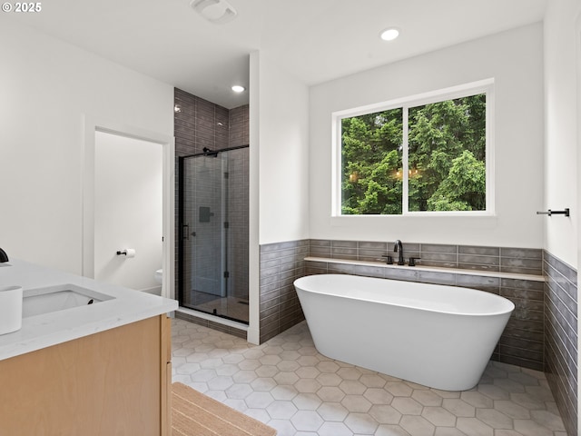 6719 NE 132nd St, Vancouver, WA 98686 - bathroom with tile walls, a soaking tub, a shower stall, tile patterned flooring, and a wainscoted wall