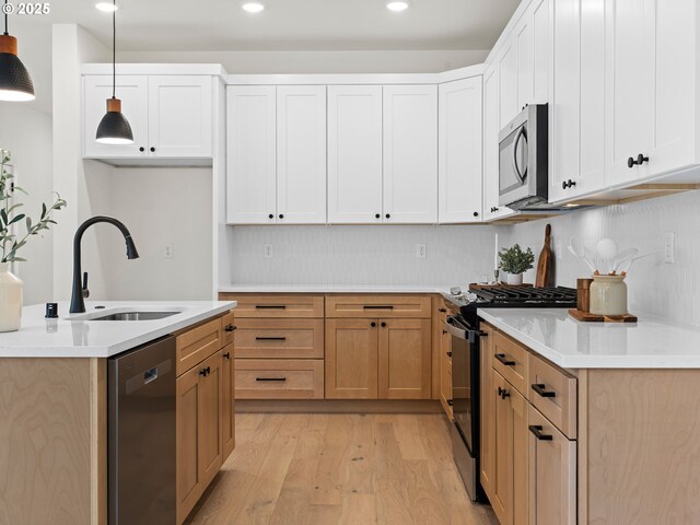 6719 NE 132nd St, Vancouver, WA 98686 - kitchen featuring appliances with stainless steel finishes, a sink, light wood finished floors, pendant lighting, and light countertops