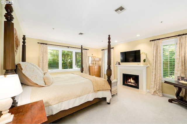 bedroom featuring carpet, crown molding, a glass covered fireplace, baseboards, and recessed lighting