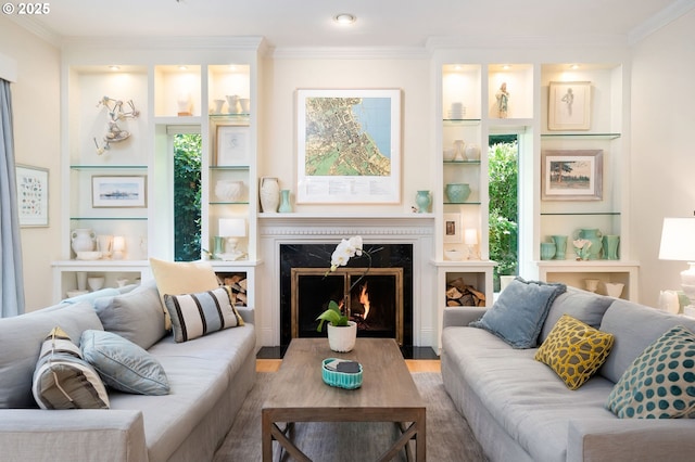 living room featuring ornamental molding, wood finished floors, a premium fireplace, built in shelves, and recessed lighting