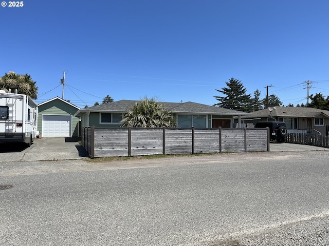 1206 Iris St, Brookings, OR 97415 - single story home with a fenced front yard and a detached garage