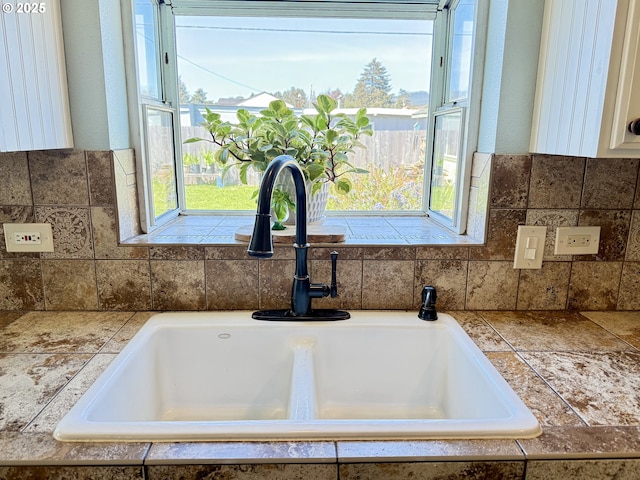 1206 Iris St, Brookings, OR 97415 - interior details featuring tile counters, tasteful backsplash, white cabinetry, and a sink