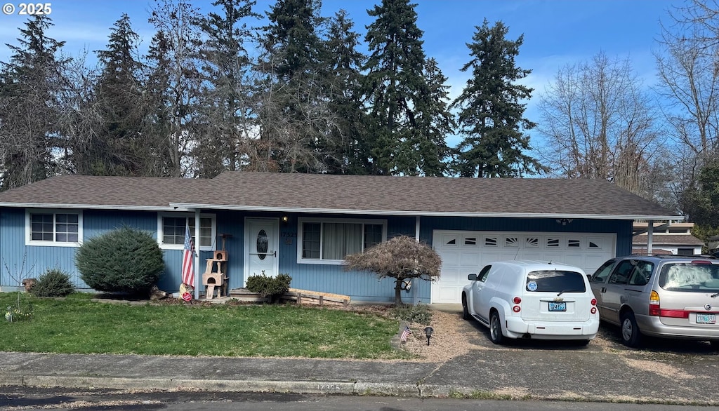 ranch-style house with an attached garage, a shingled roof, a front lawn, and aphalt driveway