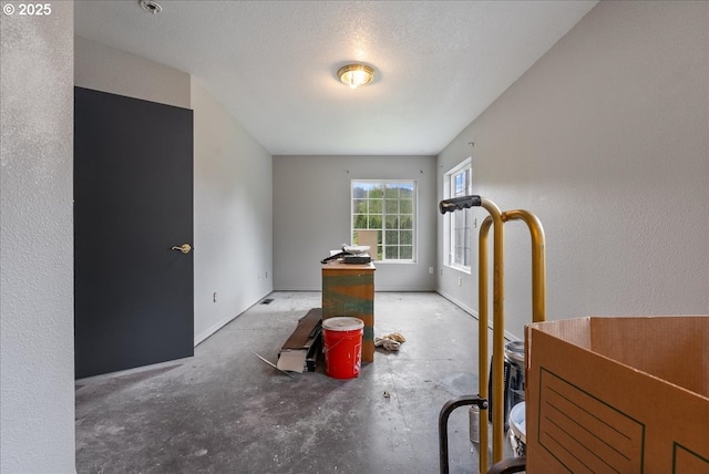 interior space featuring baseboards and concrete flooring