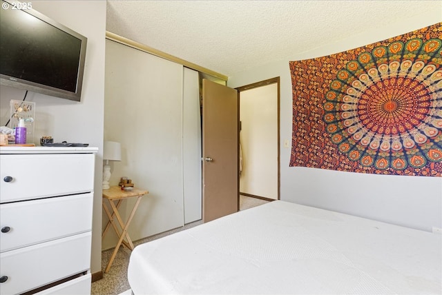 bedroom with a textured ceiling and a closet