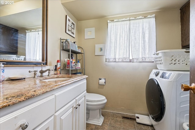 bathroom with tile patterned flooring, vanity, baseboards, toilet, and washer / dryer