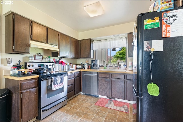 kitchen featuring dark brown cabinetry, a sink, light countertops, stainless steel appliances, and under cabinet range hood