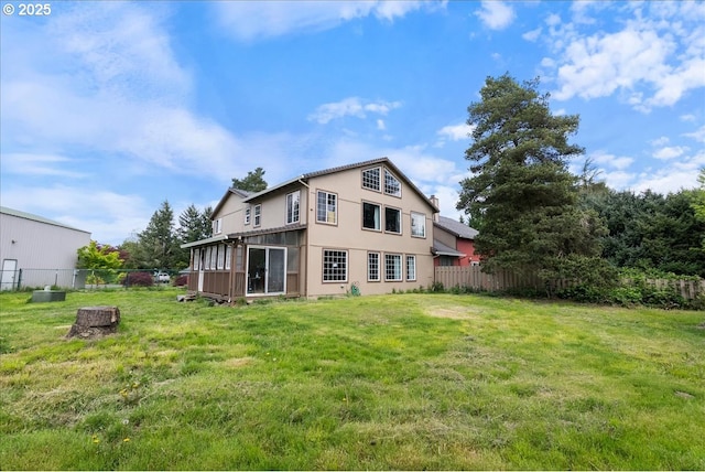 back of house with a lawn, fence, and a sunroom