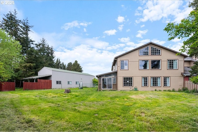 rear view of property with fence, stucco siding, and a lawn
