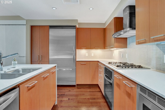 1260 NW Naito Pkwy Unit 103, Portland, OR 97209 - kitchen featuring stainless steel appliances, wall chimney exhaust hood, light wood finished floors, light countertops, and decorative backsplash
