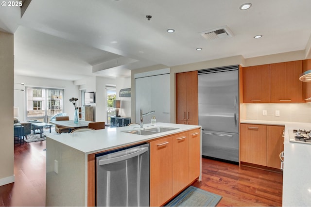 1260 NW Naito Pkwy Unit 103, Portland, OR 97209 - kitchen with stainless steel appliances, open floor plan, light countertops, wood finished floors, and decorative backsplash