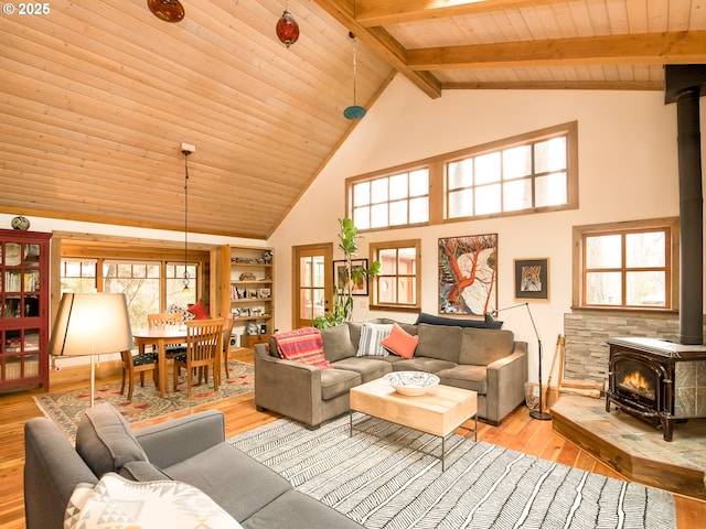 living room with beamed ceiling, wood ceiling, wood finished floors, and a wood stove