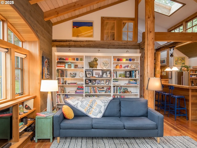 interior space with wooden walls, vaulted ceiling with skylight, wood ceiling, and wood finished floors