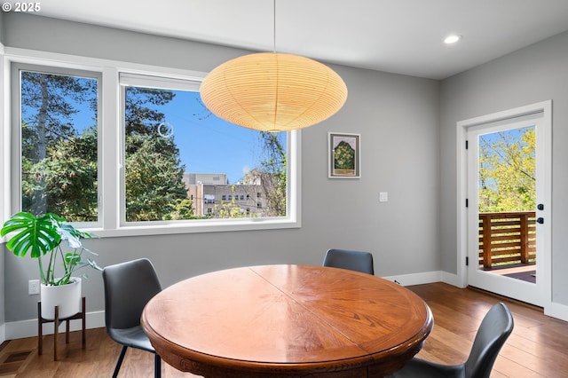 dining space with recessed lighting, baseboards, wood finished floors, and visible vents