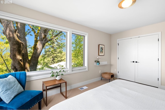 bedroom featuring baseboards, visible vents, carpet, and a closet