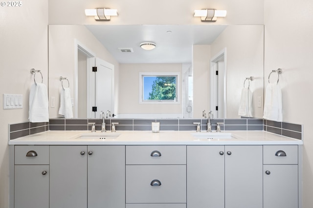 full bathroom featuring a sink, double vanity, and visible vents