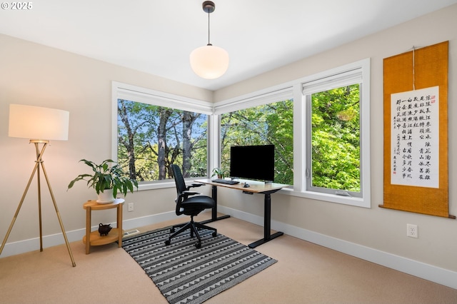 office featuring baseboards and light carpet