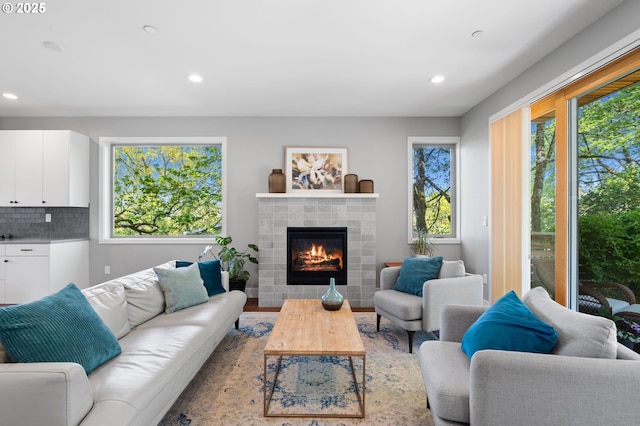 living area featuring recessed lighting, a tile fireplace, and wood finished floors
