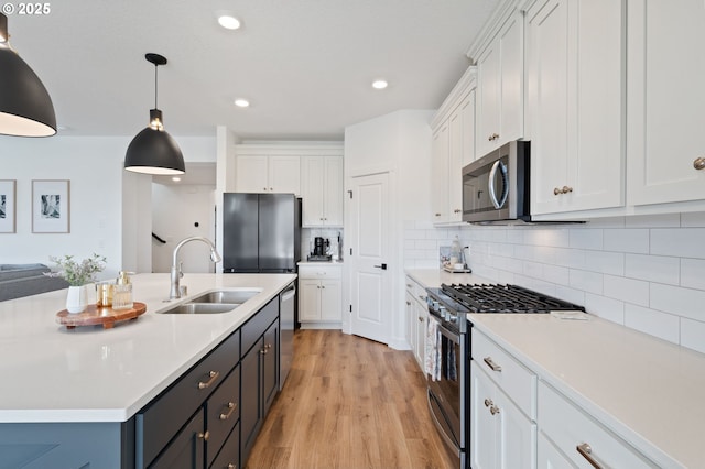 4815 S 12th Cir, Ridgefield, WA 98642 - kitchen featuring appliances with stainless steel finishes, a sink, white cabinets, light countertops, and recessed lighting