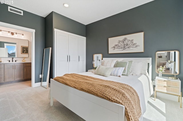 4815 S 12th Cir, Ridgefield, WA 98642 - bedroom featuring light carpet, a closet, a sink, ensuite bath, and baseboards