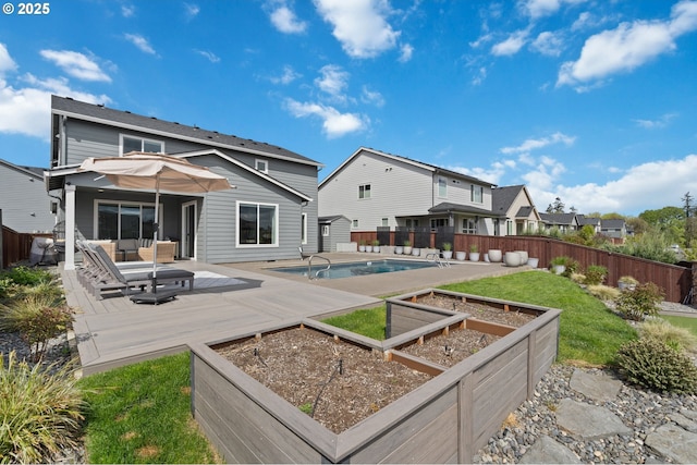4815 S 12th Cir, Ridgefield, WA 98642 - back of property featuring a vegetable garden, a fenced backyard, a wooden deck, and an outdoor hangout area