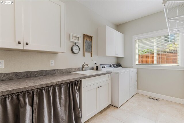 laundry area with visible vents, cabinet space, a sink, baseboards, and separate washer and dryer