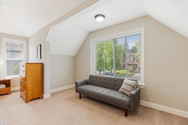 sitting room with light colored carpet, baseboards, and lofted ceiling
