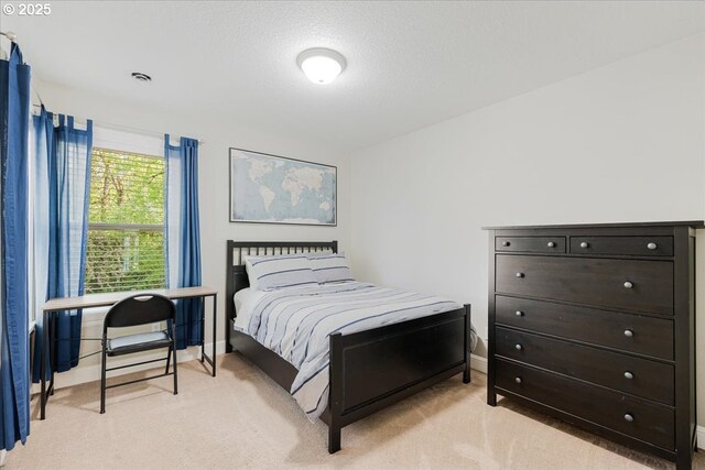 bedroom with baseboards and light colored carpet