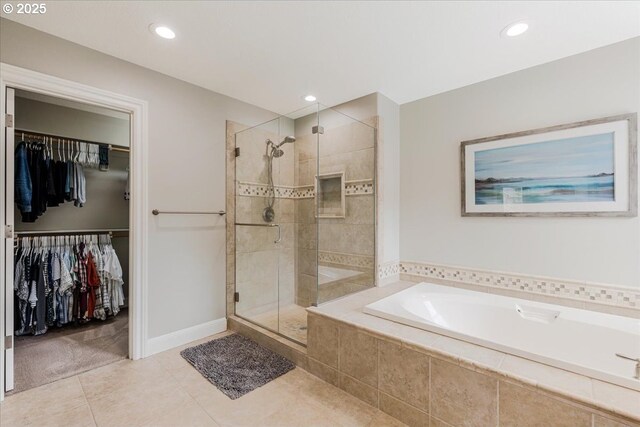 bathroom with a garden tub, a walk in closet, recessed lighting, tile patterned floors, and a stall shower
