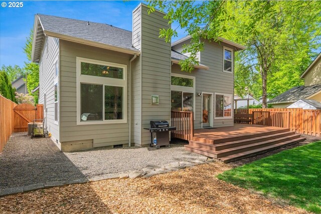 rear view of property featuring a fenced backyard, a chimney, cooling unit, and a deck