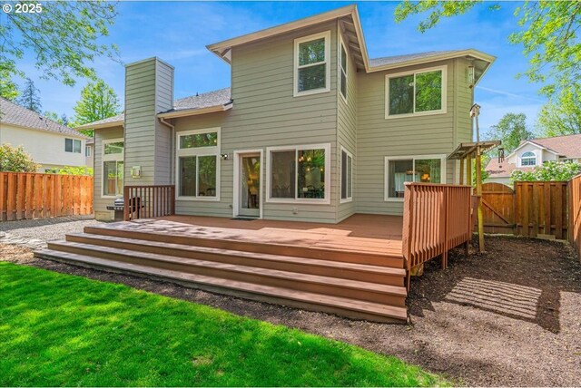 rear view of property with a chimney, a fenced backyard, a wooden deck, and a gate