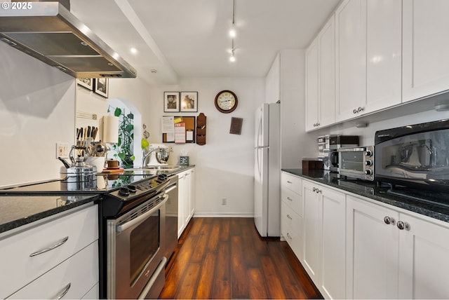 kitchen with electric stove, dark wood-style flooring, freestanding refrigerator, white cabinets, and extractor fan