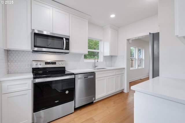 kitchen featuring a sink, light countertops, white cabinets, and stainless steel appliances