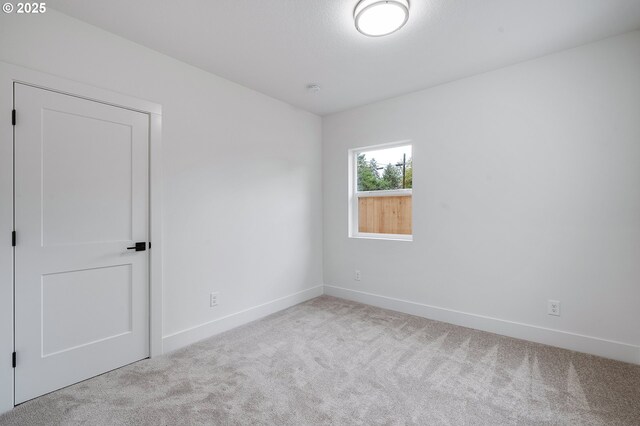 carpeted spare room with baseboards