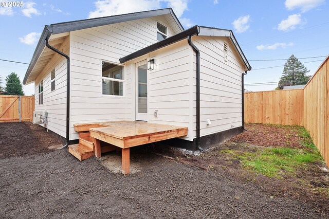 back of house featuring a fenced backyard and a deck