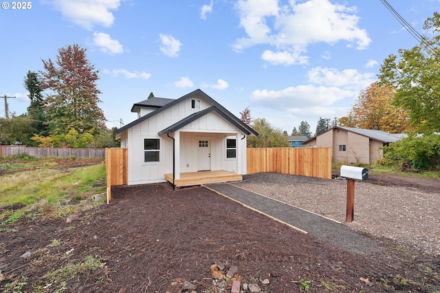 bungalow-style home featuring board and batten siding and fence