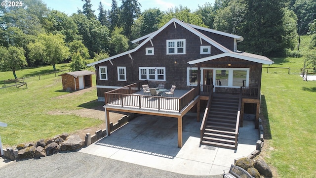 rear view of house with a storage shed, a yard, and a deck