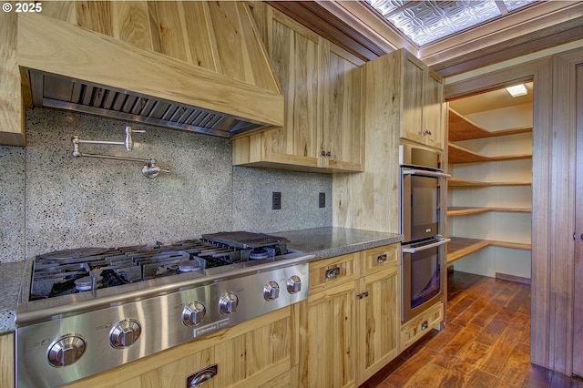 kitchen featuring light brown cabinetry, tasteful backsplash, appliances with stainless steel finishes, dark hardwood / wood-style floors, and custom range hood