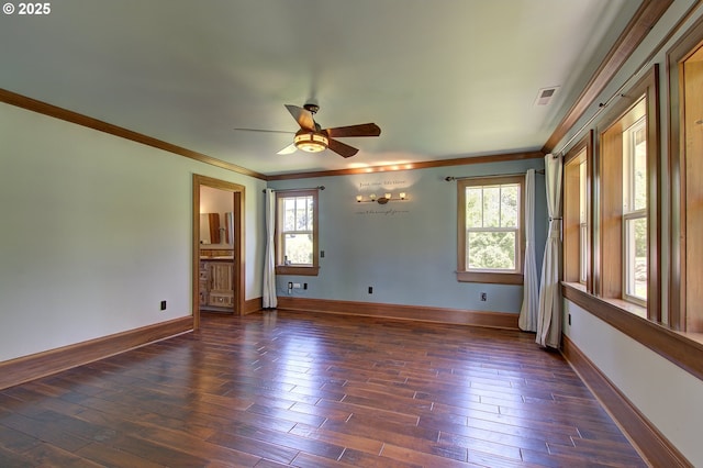 empty room with crown molding, plenty of natural light, and dark hardwood / wood-style floors