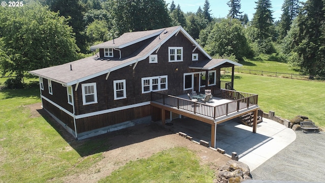 back of house featuring a wooden deck and a lawn